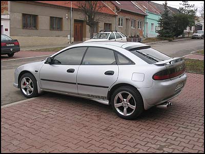 Mazda 323F, r.v.97 (model 98), 2.0i V6 GT (160 PS), najeto 145 000 km, ABS, Alu kola 16 "(Alessio), 2x AirBag, pevodovka manuln, ladn vfuk, sportovn vloka vzd. filtru K&N,  alarm - GSM pager, imobilizr, Bullock, Defend lock, centrln zam. na DO, klimatizace manuln, rdio/CD, servo, dlen zadn sedadla, el. okna, el. vyhvan zrctka, nastaviteln volant, otkomr, pdavn svtlomety, spoiler pedn a zadn, sportovn sedadla, tnovan skla, strae Bosch Aerotwin, nov ir optika a blikae, automatick dojezdy na pednch oknech a automatika na svtlech 